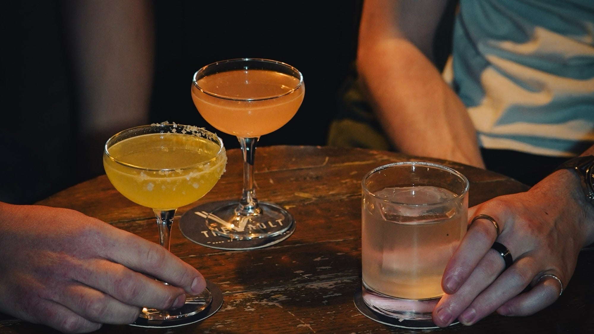 Cocktails on a Vault coaster at the table